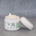 Front view of ScarSof's 2 Fl oz. jar with an easy screw-off cap. This surgeon-formulated scar cream comes in a sleek white jar, set against a grey backdrop. The label prominently displays 'ScarSof. Surgeon Formulated Scar Cream' in varying shades of green