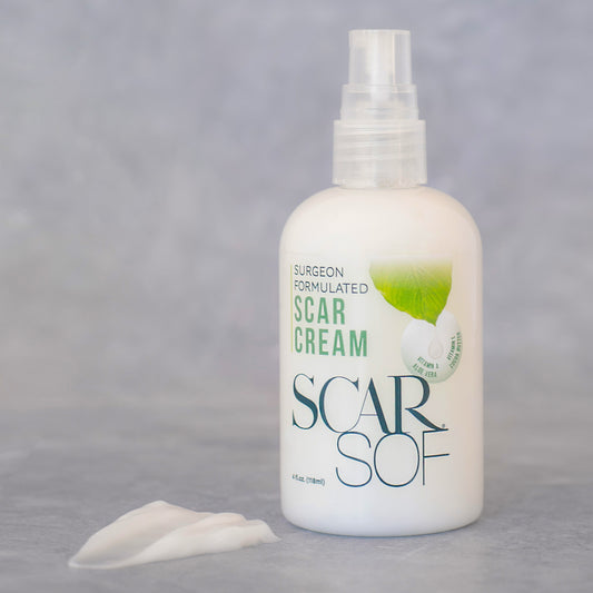 Front view of the surgeon formulated scar cream ScarSof. The 4 fl oz.bottle sports a push down pump for easy use.  The bottle is clear, allowing you to see the inside contents to allow one to easily know the product levels.  The label has an illustration of a leaf with a white drop running off of it.   A blob of the lotion rests to the left of the product, showcasing it's creamy texture.